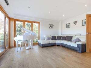 uma sala de estar com um sofá e um piano em High View House em Kemeys Inferior