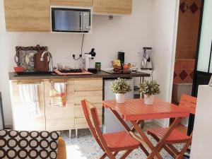 a small kitchen with a red table and chairs at VillaCarros - Studios in Sea & Mountain Villa near Nice with Idyllic View in Carros