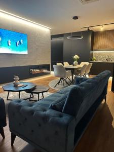 a living room with a blue couch and a table at Centar Residence in Slavonski Brod