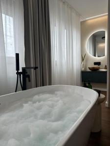 a bath tub filled with lots of water in a bathroom at Centar Residence in Slavonski Brod