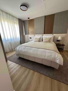 a bedroom with a large bed with white sheets and pillows at Centar Residence in Slavonski Brod
