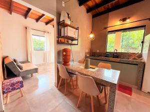 a kitchen with a counter and chairs in a room at Chalé Baru - Ar-cond - Varanda Pôr do Sol - Cavalcante Goiás in Cavalcante +44 photos