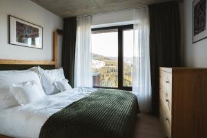 a bedroom with a bed and a large window at Chalet Paseka in Pec pod Sněžkou