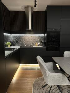 a black kitchen with a chair and a table at Centar Residence in Slavonski Brod