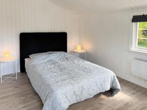 a bedroom with a bed with two tables and two lamps at Beach House Near Sejerø Bay in Hønsinge +13 photos