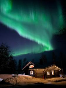 un'immagine dell'aurora boreale sopra una cabina di Villa Hackberry Hill a Rovaniemi
