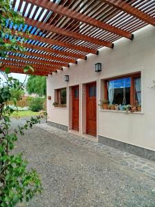 een huis met een houten pergola erop bij Amaru Apart in Cafayate