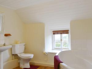 ein weißes Badezimmer mit Toilette und Badewanne in der Unterkunft Mulberry Cottage - 27905 in Langton Matravers