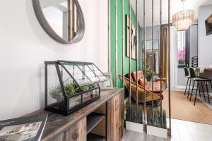 een kamer met een tafel met planten en een spiegel bij Beprime San Felipe Neri in Málaga