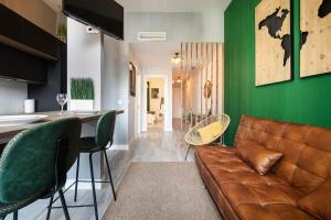 een woonkamer met een bruine bank en een groene muur bij Beprime San Felipe Neri in Málaga