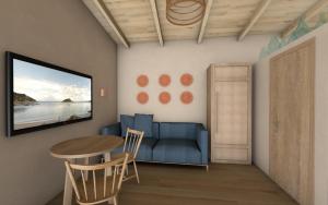 Una sala de estar con un sofá azul y una mesa. en Katoi suite, en Éxo Khóra