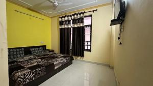 a bedroom with a bed and a window at Ghar by the mountains in McLeod Ganj