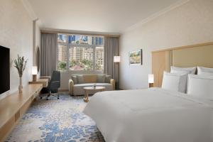 una camera d'albergo con un grande letto e un soggiorno di Swissôtel Al Murooj Dubai a Dubai