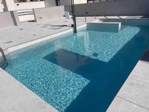 een zwembad met blauw water in een gebouw bij Beprime San Felipe Neri in Málaga