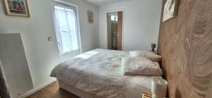 a bedroom with a bed and a window at L'Espadon in Luc-sur-Mer