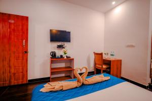a room with a bed with a towel animal on it at The Nature's Nest in Attigundi