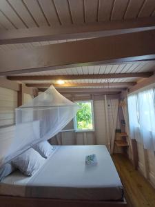 a bedroom with a bed in a small room at Caraïbes Cottages Le Jasmin vue mer a 500m de la plage in Deshaies