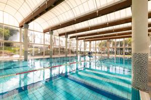 a large indoor swimming pool with blue water at Rose Suite in Caesarea