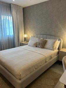 een slaapkamer met een groot wit bed met een raam bij REFA - 404 · Luxury 1BR Suite in Piantini | Modern • Pool • Gym in La Julia