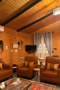 a living room with two chairs and a flat screen tv at كوخ سترين in Tabuk