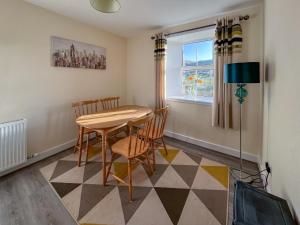 ein Esszimmer mit Tisch und Stühlen und einem Fenster in der Unterkunft Ballygroggan Cottage - Uk48768 in Machrihanish
