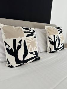 un letto con due cuscini bianchi e neri sopra di The Hideaway Haven With Private Self Check-In a Belvedere