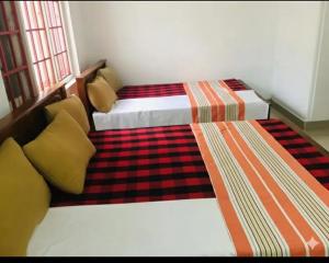 Habitación pequeña con 2 camas en NK Hotel and Restaurant, en Matale