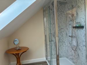 een badkamer met een douche en een houten tafel bij Meadow View House at Pudleston Court in Docklow +9 foto's