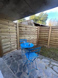 einem blauen Tisch und Stühlen vor einem Zaun in der Unterkunft Casa Tropical in Les Ponts-de-Cé