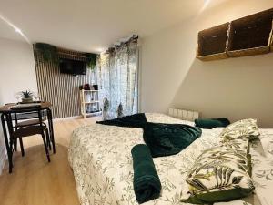 ein Schlafzimmer mit einem Bett und einem Tisch und einem Fenster in der Unterkunft Casa Tropical in Les Ponts-de-Cé