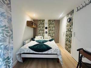 ein Schlafzimmer mit einem Bett, auf dem eine grüne Schüssel steht in der Unterkunft Casa Tropical in Les Ponts-de-Cé