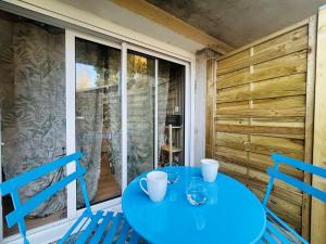 einen blauen Tisch und Stühle in einem Zimmer mit Fenster in der Unterkunft Casa Tropical in Les Ponts-de-Cé
