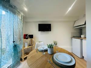 ein Esszimmer mit Tisch und Fernseher in der Unterkunft Casa Nature in Les Ponts-de-Cé