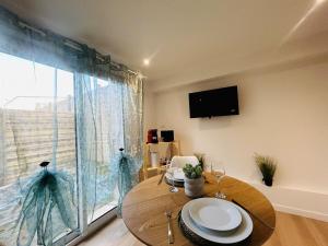 ein Esszimmer mit einem Tisch und einem großen Fenster in der Unterkunft Casa Nature in Les Ponts-de-Cé