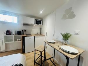 a room with a kitchen and a table with plates on it at Casa Rubis in Les Ponts-de-Cé