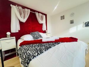 a bedroom with a bed with a red headboard at Casa Rubis in Les Ponts-de-Cé