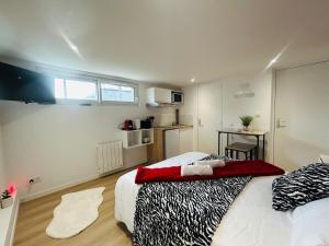 a bedroom with a large bed and a kitchen at Casa Rubis in Les Ponts-de-Cé