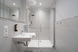グラール・ミューリッツにあるHotel Ostseewogeのシャワーと洗面台を備えた白いバスルーム +32枚の写真