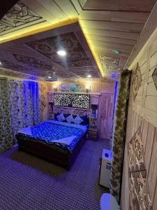 a bedroom with a bed in a room with purple lighting at Houseboat Quebec in Srinagar