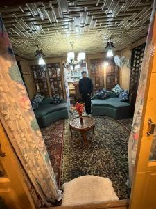 a man is standing in a living room at Houseboat Quebec in Srinagar