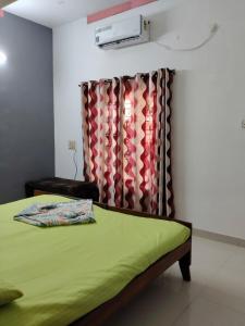 コーラムにあるSunny's Holiday Homesの緑のベッドと広告付きの寝室 +2枚の写真