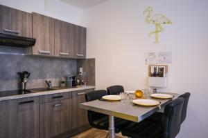 een keuken met een tafel met stoelen en een wastafel bij Appartement Centre Saint-Omer, Parking privé gratuit in Saint-Omer