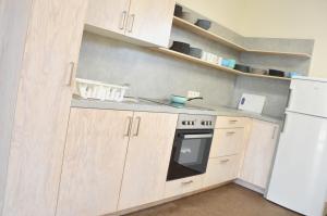 a kitchen with wooden cabinets and a white refrigerator at Gruppenunterkunft am Waldsee in Krefeld