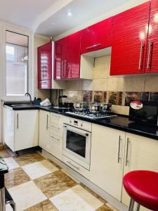 una cucina con armadi rossi e uno sgabello rosso di Центр. Хмельницького. 2 спальні a Ternopilʼ Altre 7 foto