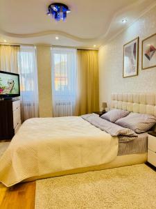 una camera da letto con un letto grande e una TV a schermo piatto di Центр. Хмельницького. 2 спальні a Ternopilʼ