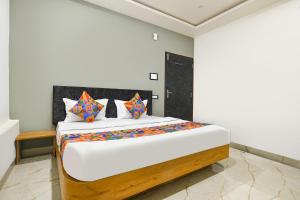 a bedroom with a large bed with colorful pillows at FabHotel Paradise Inn in Indore