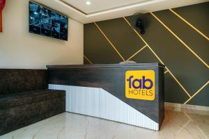 a reception area of a hotel with a sign on the wall at FabHotel Paradise Inn in Indore