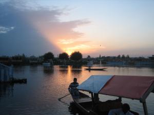 two people in a boat on the water at sunset at Houseboat Quebec in Srinagar