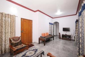 Una sala de estar con una silla y un televisor. en Srishti Homestay, en Madikeri