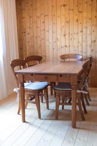 a wooden table with chairs and a wooden wall at Scharnitz Chalet - gut eingerichtetes Haus in Scharnitz